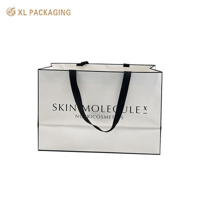 Saco de presente de papel artístico revestido de branco fosco luxuoso de marca personalizada com alça larga de fita preta tecida para varejo de cosméticos