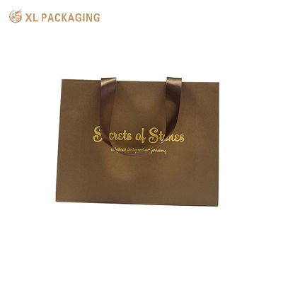 Saco de presente de papel de luxo com estampagem a quente em folha de ouro, alças largas de fita de cetim e fundo dobrável triangular