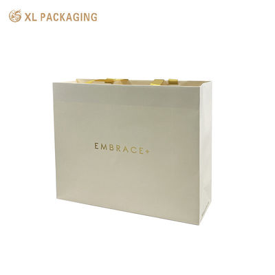 Saco de presente de papel estampado em folha de ouro personalizado premium com alças de fita de cetim e parte superior dobrada reforçada